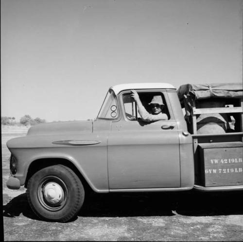 Nicholas England sitting in the driver's seat of an expedition truck, looking out the window