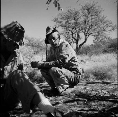 Nicholas England sitting, with another expedition member squatting next to him