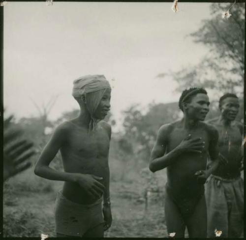 /Ti!kay, an unidentified man and Tsamgao playing the "hitting game"