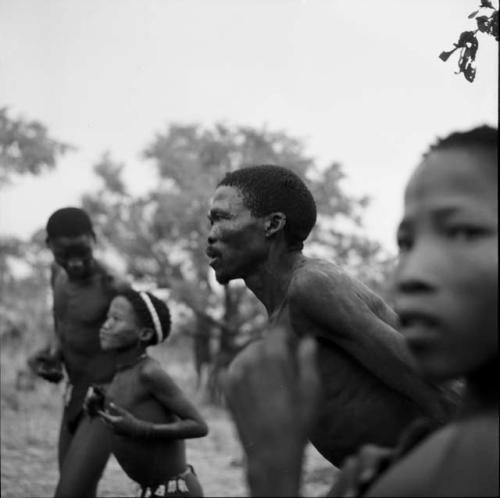 Men and boys playing the "hitting game," standing and clapping