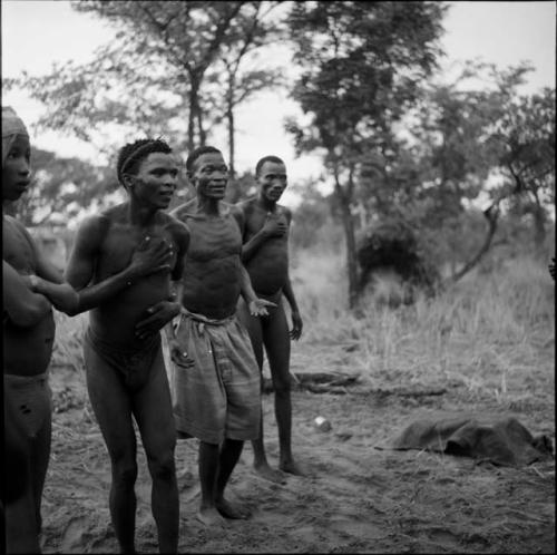 Four men playing the "hitting game"