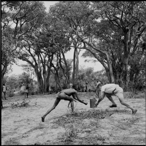 Man and an expedition member reaching to catch a ball, playing baseball