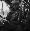 Woman sitting, holding a baby