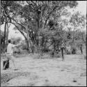 Men playing baseball with expedition members, with Robert Story preparing to catch the ball