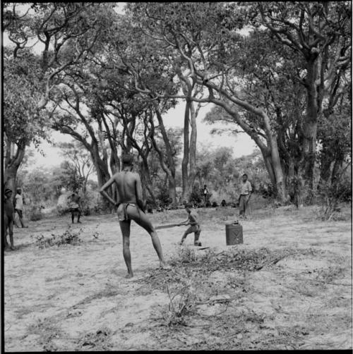 Boy hitting a ball with a bat, playing baseball with expedition members