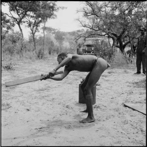 Man swinging a bat, playing baseball with expedition members