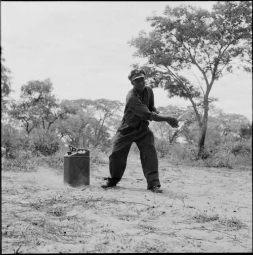 Man wearing Western clothes hitting a ball with a bat, playing baseball with expedition members