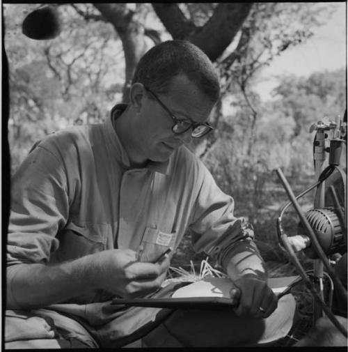 Nicholas England taking notes next to a microphone