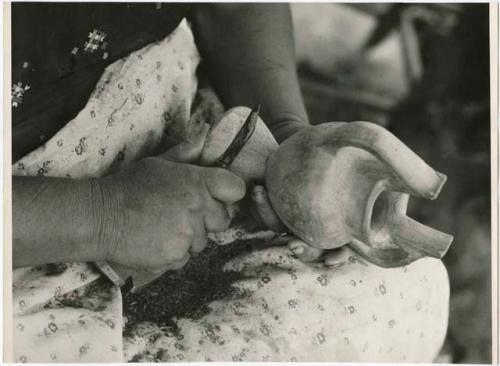 Woman scraping pot