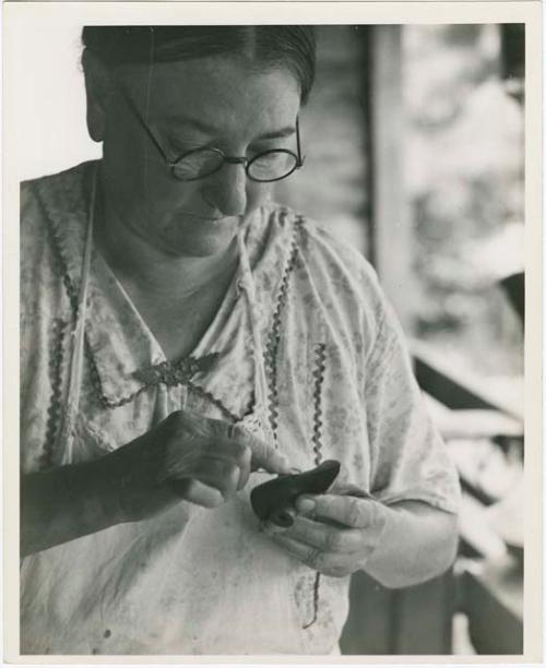 Woman working on a small pottery object