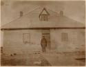 Man and dog front of building at Fort McPherson (Teetå'it Zheh)