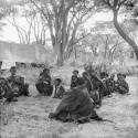 Large group of people sitting, with an expedition tent in the background