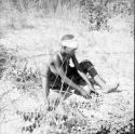 Woman sitting, with a pile of nuts on the ground in front of her