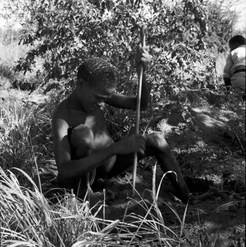 Man digging for roots with his digging stick