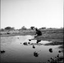 Woman sitting at the edge of a pan, bathing