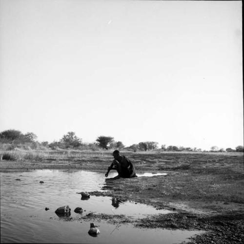 Woman sitting at the edge of a pan, bathing