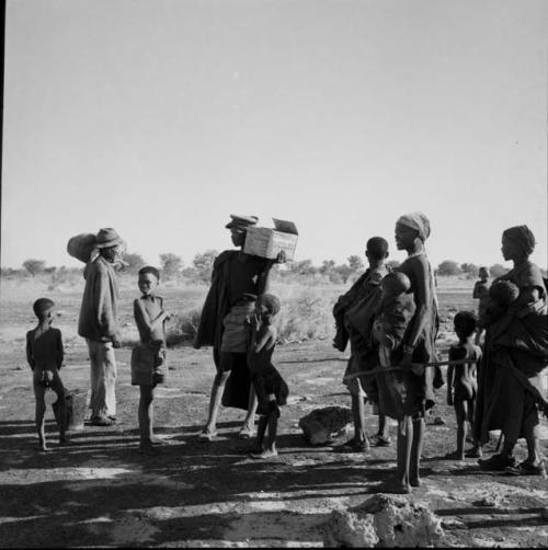 Group of people carrying their belongings, preparing to go to a pan