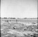 People standing and sitting at the edge of a pan, distant view