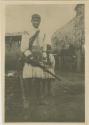 Muskogean Seminole man with gun, child behind him