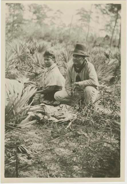 Two women by fire in camp