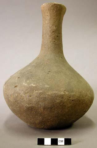 Ceramic vessel, long neck, flared at rim, depression in base, plain.