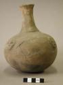 Ceramic complete vessel, 4 human heads on shoulder, long flared neck, and ridge