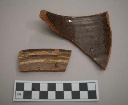 Earthenware, lead glazed,  slip glazed, dark reddish brown; vessel rim fragments, 1 rim fragment with yellow slip decoration