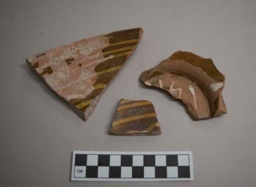 Earthenware, slipware, North Midlands type, yellow and blue on brown; sherds, unglazed exterior, trailed slip design