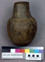 Jar of polished black ware, incised decoration, contained remnants of beer