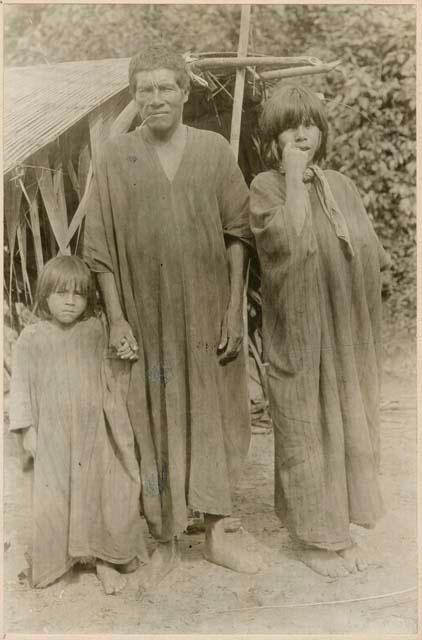 Man and his two sons standing in front of structure