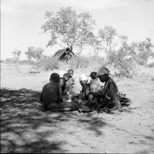 Group of people sitting, with an expedition tent in the background