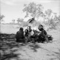 Group of people sitting, with an expedition tent in the background