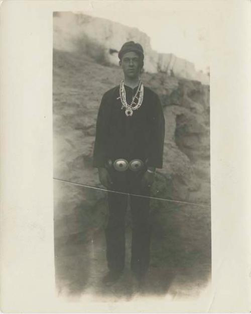 Man standing in front of a rock outcrop