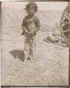 Child standing next to wagon wheel