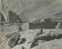 Two people seated near cliff dwelling