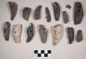 Perforated animal teeth fragments, burned and calcined