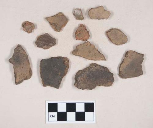 Coarse earthenware body sherds, some undecorated, one cord impressed; charcoal fragments; mica fragments; chipped stone, flake; shell fragment; bone fragments