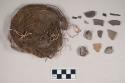 Stone fragments; charcoal fragments; burned and calcined bone fragment; earthenware body and rim sherds, some burnished; floral material, possible root mat, with some bone fragments attached