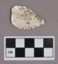 Organic, utilized shell fragment, notched edge