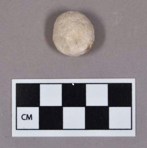 Ground stone, white chalky pebble, indented