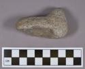 Ground stone, L-shaped fragment, partially perforated on one end, heavily pecked surface; possible pipe preform