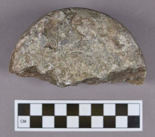 Ground stone, pitted pounding stone fragment