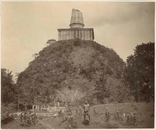 Buddhist monk standing in front of stupa