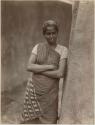 Tamil woman leaning against a tree