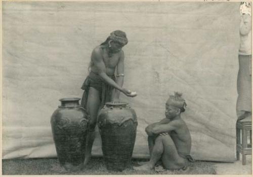 Two men bargain over Japanese jars