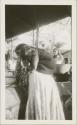 Woman with child on her back at public washing station, possibly Antigua