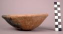 Ceramic bowl, rounded base, flaring sides, straight rim, red slip