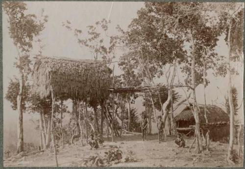 Four boys in front of huts