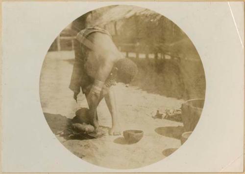 Woman forming the base of a pot