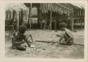 Men making a spear and a head rest